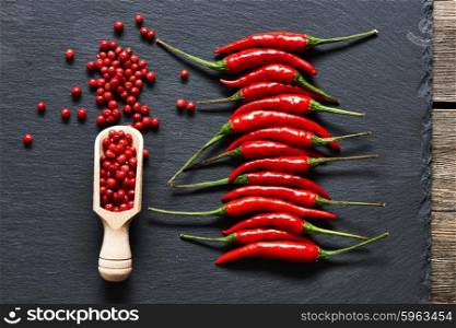 Red hot chili peppers and rose pepper on slate background