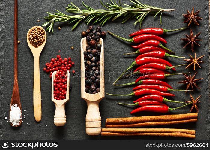 Red hot chili peppers and spices on slate background