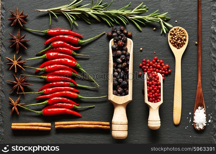 Red hot chili peppers and spices on slate background