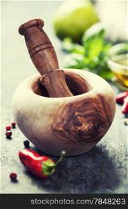 Red Hot Chili Peppers, herbs and spices with Mortar and Pestle over wooden background