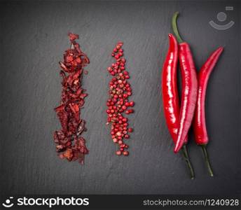 Red hot chili peppers on black stone background. top view