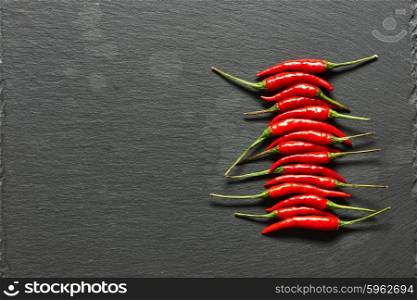Red hot chili peppers on slate background
