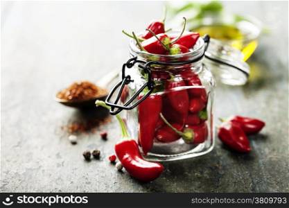 Red Hot Chili Peppers with herbs and spices over wooden background - cooking or spicy food concept