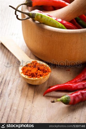 Red hot chilli pepper in wooden mortar on table