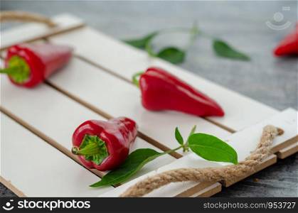 Red hot peppers are on white wood tray.Selective focus,