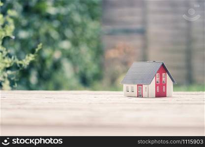 Red house model on the floor, outdoors. Concept for new home, property and estate, copy space