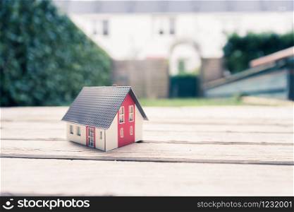 Red house model on the floor, outdoors. Concept for new home, property and estate