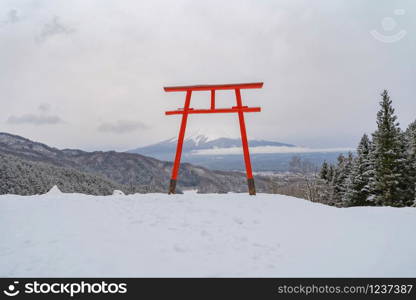 Red Japanese Torii pole, Fuji mountain and snow in Kawaguchiko, Japan. Forest trees nature landscape background in winter season.