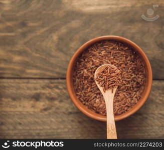 red jasmine rice grains spoon bowl against wooden backdrop. Resolution and high quality beautiful photo. red jasmine rice grains spoon bowl against wooden backdrop. High quality beautiful photo concept