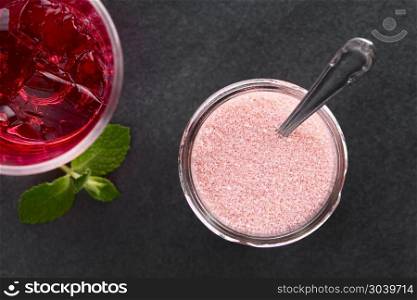 Red jelly or jello powder in jar with spoon, prepared red jelly on the side, photographed overhead on slate (Selective Focus, Focus on the jelly powder and the prepared jelly). Red Jelly or Jello Powder