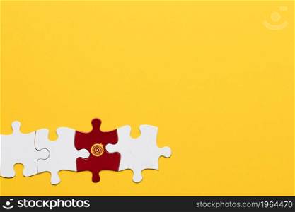 red jigsaw puzzle piece with dartboard symbol arranged with white piece yellow background. High resolution photo. red jigsaw puzzle piece with dartboard symbol arranged with white piece yellow background. High quality photo