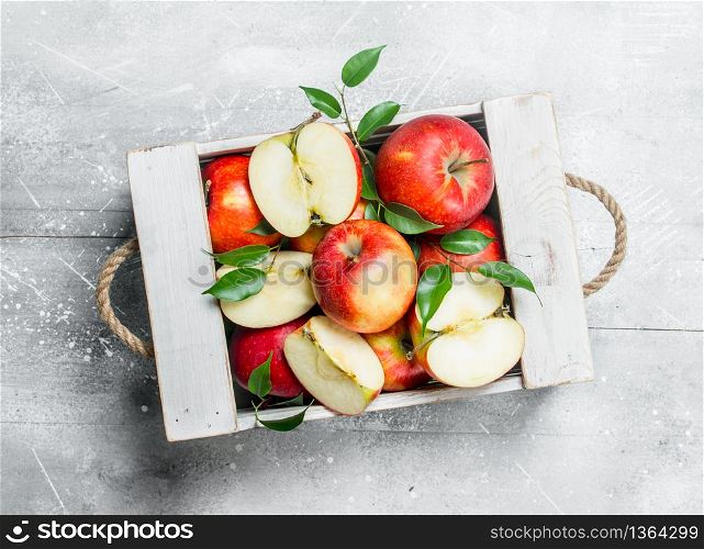 Red juicy apples and Apple slices in a wooden box.On rustic background.. Red juicy apples and Apple slices in a wooden box.