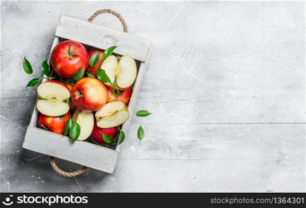 Red juicy apples and Apple slices in a wooden box.On rustic background.. Red juicy apples and Apple slices in a wooden box.