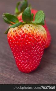 red juicy strawberry on a wooden surface