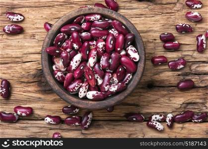 Red kidney beans in a bowl. Close-up red kidney bean on wooden rustic background