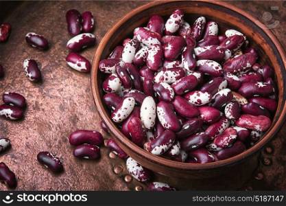 Red kidney beans in bowl. Close-up red kidney bean on metal background