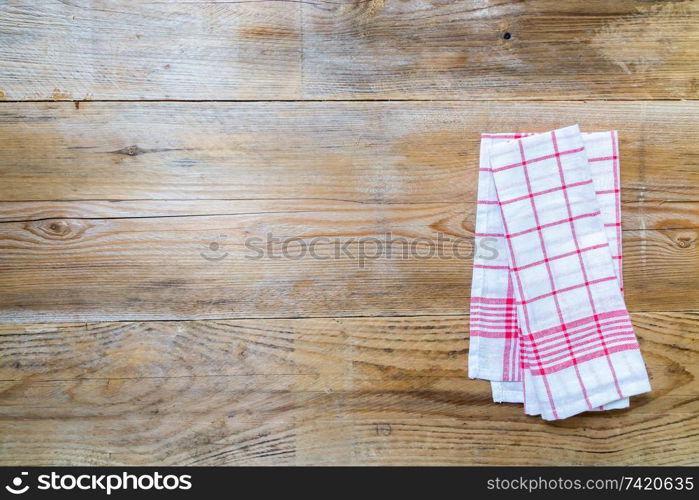 Red kitchen towel on rustic wooden background.. Red kitchen towel on rustic wooden background