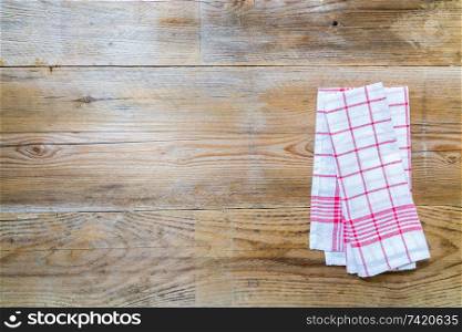 Red kitchen towel on rustic wooden background.. Red kitchen towel on rustic wooden background