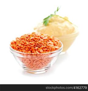 Red lentils and lentil hummus in bowls on white background