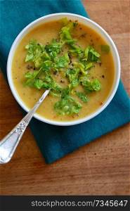 Red lentils soup with spices and salad