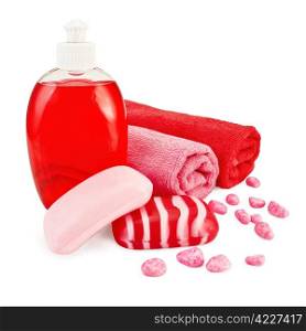 Red liquid soap in a bottle, solid red striped and pink soap, bath salt, two towels isolated on white background
