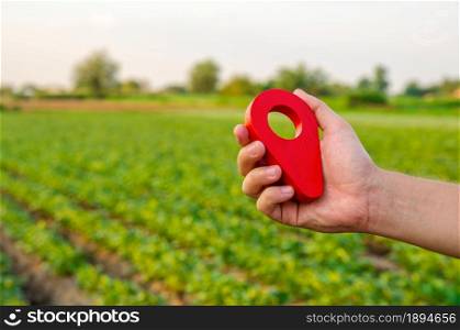 Red location pin on farm field. Buying and selling on land market. Plot Boundary Demarcation service. Legal regulation of property. Agriculture and agribusiness. Land tenure, landownership