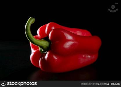 Red macro pepper over black background
