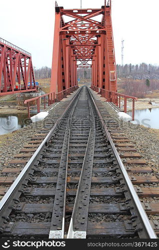 Red metal railway bridge across the river.