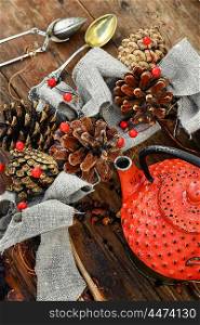 Red metal teapot,tea leaves and autumn pine cones