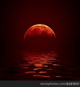 Red moon reflected in a wavy water surface