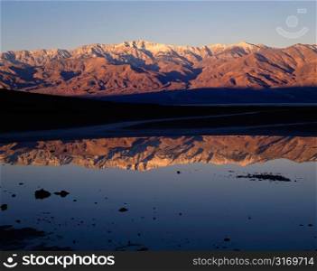Red Mountains Reflected In A Still Lake