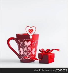 Red mug with hearts and gift box with ribbon standing on white background. Declaration of love and Valentines day concept