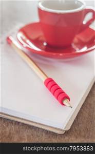 Red mug with open notebook, stock photo