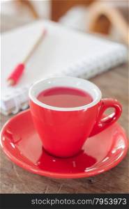 Red mug with open notebook, stock photo