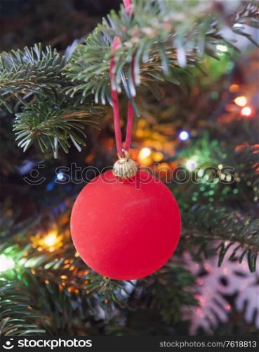 Red New Year&rsquo;s ball on a branch of a Christmas tree