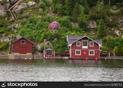 red norwegian houses on a lake coast