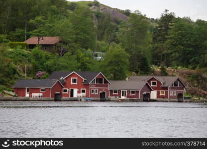 red norwegian houses on a lake coast