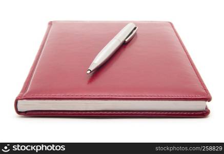 Red notebook and pen isolated on white