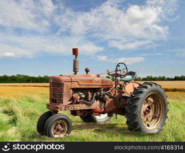 red old rusty tractor in a field