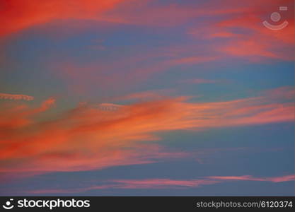 Red orange clouds in dramatic sunset blue sky