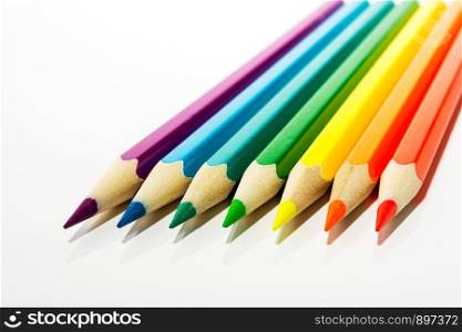 Red, orange, yellow, green, blue, purple kid's colored pencils as a symbol of first steps of artist