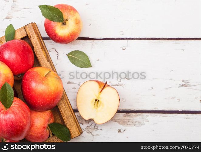 Red organic healthy apples in vintage box on wooden background.