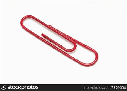 Red paper clip on white background