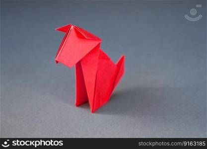 Red paper dog origami isolated on a blank grey background.. Red paper dog origami isolated on a grey background