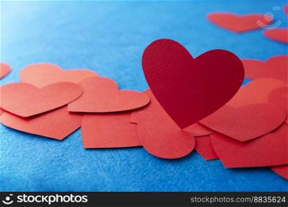 Red paper heart shape on blue textured background with copy space. Love Concept image. Valentine’s day, mother’s day, birthday greeting cards, invitation