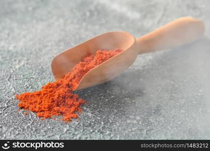 Red paprika in wooden scoop close-up