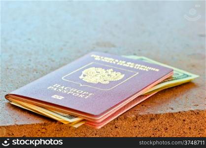 red passport with dollars on marble surface