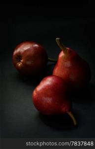 Red pears over dark background, selective focus