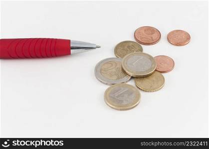 Red pen and coins on white background