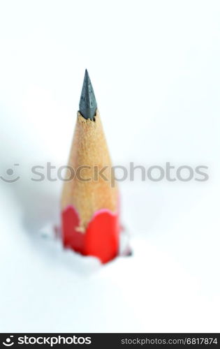 Red pencil going through a white torn paper